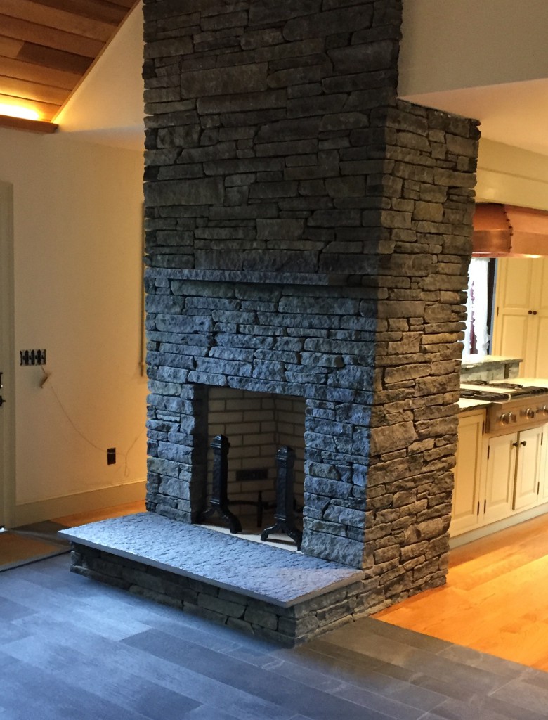 Fireplace with snapped facade, cleft hearth and satin planked flooring.